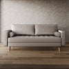 Beige sofa against a textured wall on a wooden floor