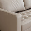 Close-up of a beige leather sofa with tufted backrest