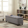Gray tufted ottoman in a living room setting with books and decor items.