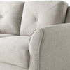 Close-up of a light gray sofa with tufted backrests