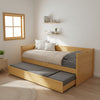 Wooden bed with pull-out trundle in s guest room