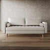 Beige sofa against a textured wall on a wooden floor