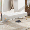 White bench with gold legs in a room with a coat hanging on a rack and slippers on the floor.