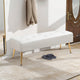 White bench with gold legs in a room with a coat hanging on a rack and slippers on the floor.