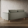 Green sofa on a wooden floor with a textured wall background