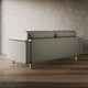 Green sofa on a wooden floor with a textured wall background