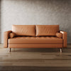 Brown leather sofa against a textured wall.