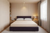 Beige mattress on a purple bed frame Inside the bedroom of a tiny home