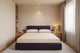Beige mattress on a purple bed frame Inside the bedroom of a tiny home